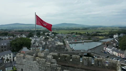 Alt flying clockwise around flag atop Castle Rushen in Castletown Isle of Man Stock Footage 157035735