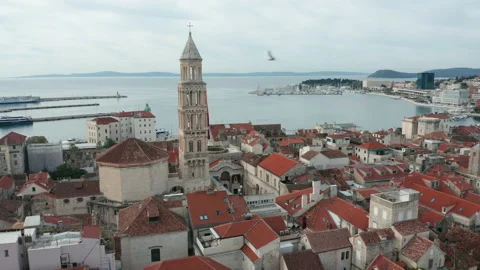 Alt view of iconic bell tower of Split Croatia flying bkward over town wall Stock Footage 142238043