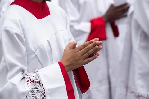 Altar servers in prayer during a religious celebration. Stock Photos
