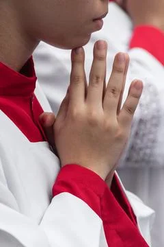 Altar servers in prayer during a religious celebration. Stock Photos