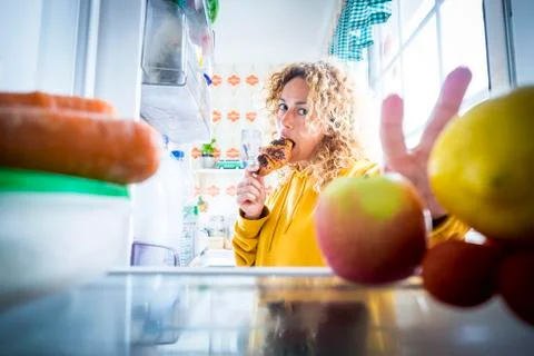 Alternaive inside view of Beautiful hungry adult woman eat tasty croissant wi Foto stock
