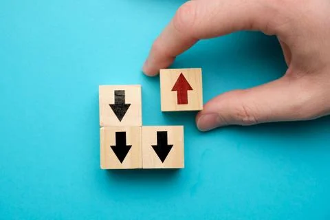 Alternative business development concept - hand holds wooden cube with red ar Stock Photos
