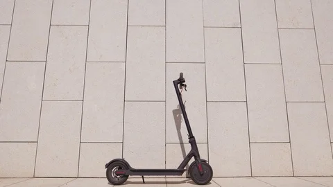 Alternative eco mode of mobile transport. Electric scooter next to the concrete Stock Footage 116403570