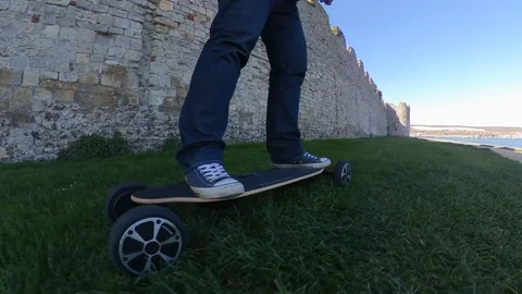 Alternative low level parallax shot of a man riding an electric skateboard Video stock 107002022