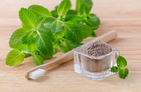 Alternative natural toothpaste clay, ash and wood toothbrush, mint on wooden Stock Photos