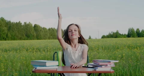 Alternative school education in nature. Elementary school age girl raising hand Stock Footage 156514722