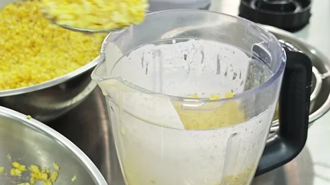 Alternative view of adding steamed yellow split mung beans into a blender jar. Stock Footage 346605342