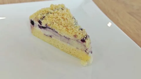 Alternative view of a blueberry crumble cake slice on a plate. Vídeo Stock 344747442