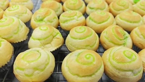 Alternative view of fresh baked Thai pandan custard buns on wire rack. Vídeo Stock 344035029
