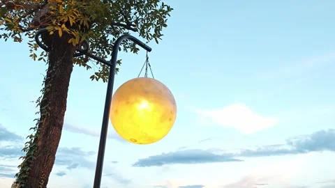 Alternative view of a giant glowing moon replica against a blue sky. Stock Footage 347456776