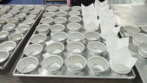 Alternative view of placing white tulip paper liners into aluminium cups. Stock Footage 346709791
