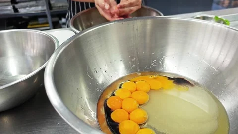 Alternative view of raw egg yolks and sugar in a mixing bowl. Vídeo Stock 346610997