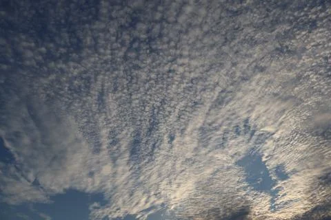 Altocumulus clouds in a blue sky create a beautiful natural background Stock Photos