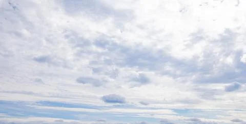 Altocumulus clouds layer a pale blue sky, soft cloudscape fading into overc.. Fotos de archivo