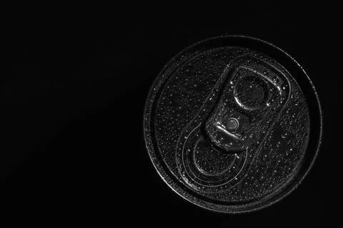 Aluminum can of beverage covered with water drops on black background, top vi Stock Photos