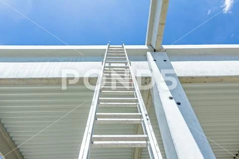 Aluminum ladder pointing towards on next level, concrete edifice Stock Photos