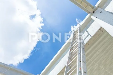 Aluminum ladder pointing towards on next level, concrete edifice Stock Photos