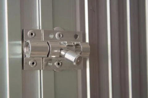 Aluminum latch on an aluminum door frame, brand new and shiny Stock Photos