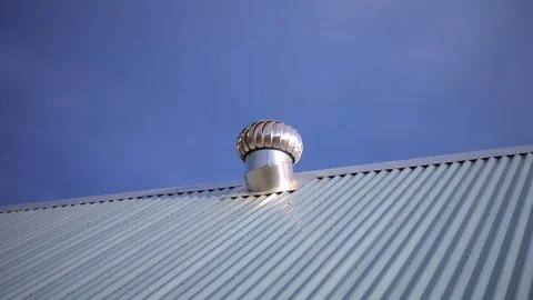 An aluminum shining mill vent ventilator on rooftop, blue sky background. Stock Footage 78476997