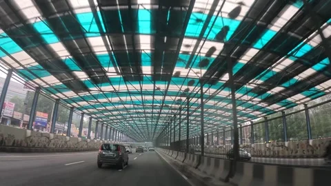 Alwar, December 27, 2024. Traffic through Colorful Canopy Over Urban Highway Stock Footage 296572002