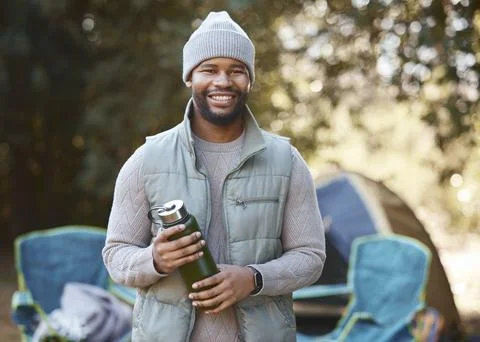 Always have refreshments when camping. a young man holding his drink flask Stock Photos