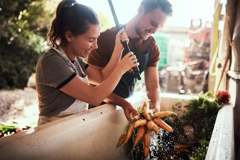 Always keep your fresh produce germ free. a happy young couple cleaning and Stock Photos