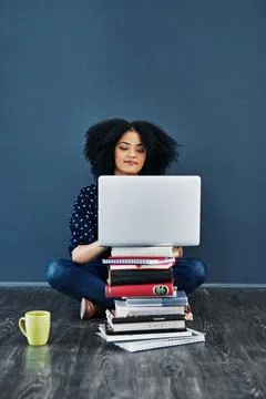 Always seek out knowledge. Studio shot of a young woman using a laptop with b Stock Photos