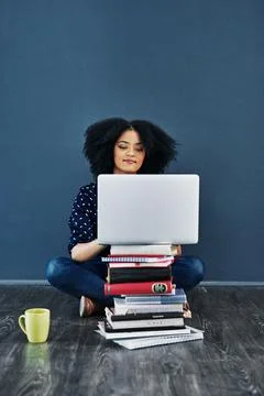 Always seek out knowledge. Studio shot of a young woman using a laptop with Stock Photos