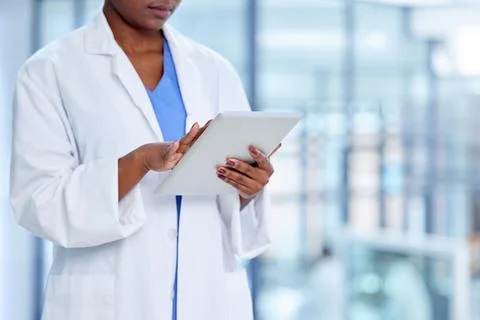 Always staying knowledgeable. Shot of an unrecognizable doctor using a digita Stock Photos