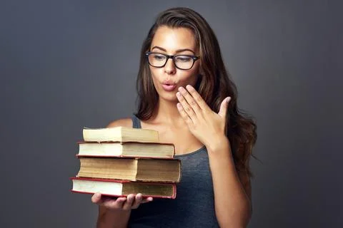 Am I suppose to study all of these. Studio shot of a young woman looking shocked Stock Photos