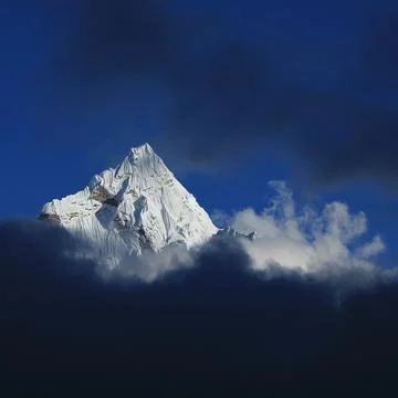 Ama Dablam reaching out of clouds, autumn scene Nepal. Stock Photos