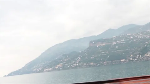 Amalfi coast mountain tip in water wide shot from moving driving vehicle Stock Footage 252150075