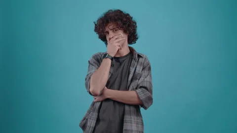 Amazed 20-year-old man, with his hand to his mouth, looks directly into the room Video stock 151716624