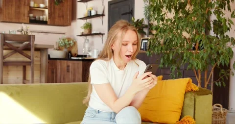 Amazed and surprised woman reading good news on phone rejoices and shouts yes Stock Footage 139831653