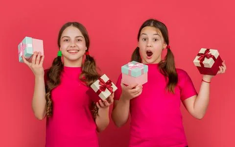 Amazed children with present boxes on red background Stock Photos