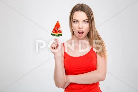 Amazed excited young female holding watermelon shaped lollypop Stock Photos