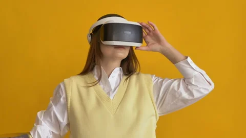 Amazed lady with bionic arm uses VR headset on yellow Stock Footage 150181058