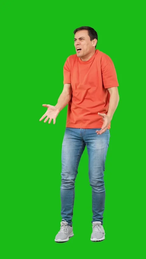 Amazed man touching cheek in studio. Green background 動画素材 244743415