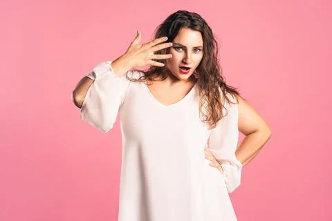 Amazed plus size model with wide open mouth on pink background Stock Photos