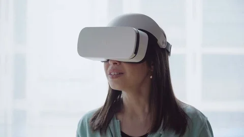 Amazed woman using vr head-mounted display against window Stock Footage 74600545