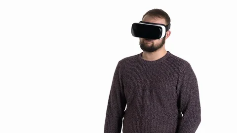 Amazed young man using virtual reality glasses. Bearded caucasian man wearing VR Stock Footage 121199660