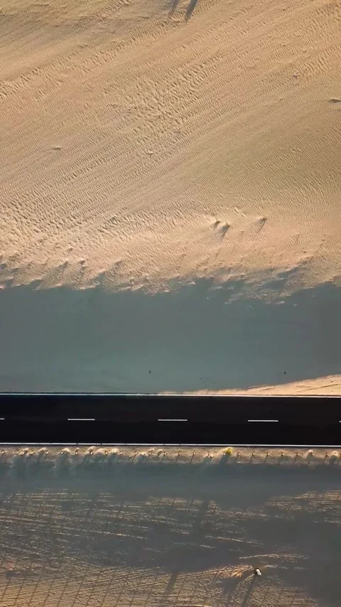 Amazing aerial top-down view showing a car driving on an empty desert road Stock Footage 344820451