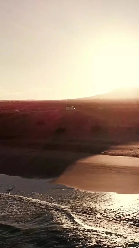 Amazing aerial view of a dramatic sunset over a stunning beach with waves Stock Footage 344847951