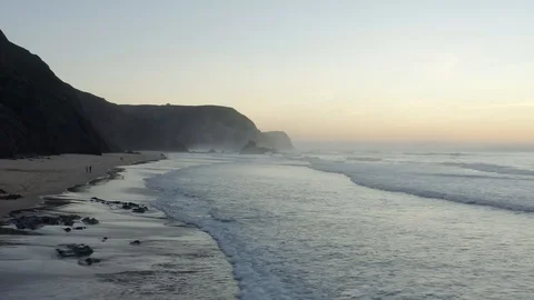 Amazing Aerial View Of Massive Cliffs Large Beach And Big Waves Shrouded In Fog Stock Footage 128842626