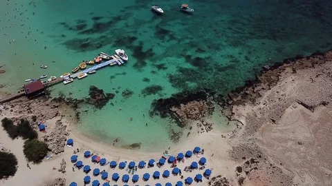 Amazing aerial view of a sandy beach with clear turquoise water and rocks Video stock 123775902