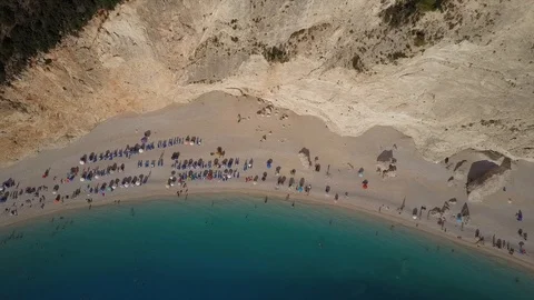 Amazing beach steep cliffs in an aerial view. turquoise blue water boat parasol Stock Footage 90964642