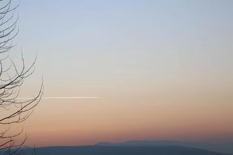Amazing capture of a trace of plane during sunset Stock Photos