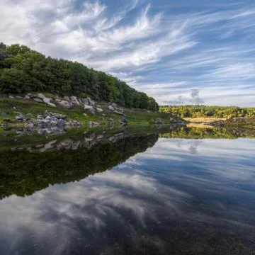 Amazing cloud formations reflected in the still waters of a river Stock Photos