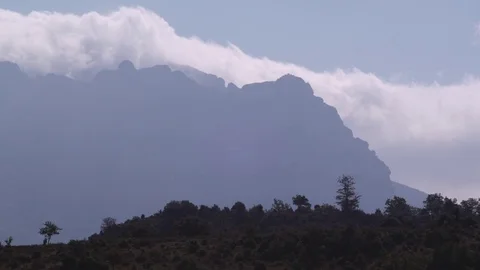 Amazing clouds passing behind a rocky mountain Stock Footage 71716473