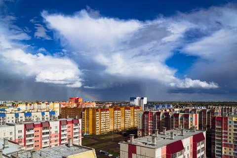 Amazing cloudy landscape above multi-colored residential buildings Stock Photos